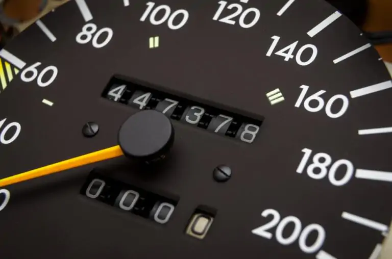 A close-up of a car's speedometer with the needle pointing to 140.