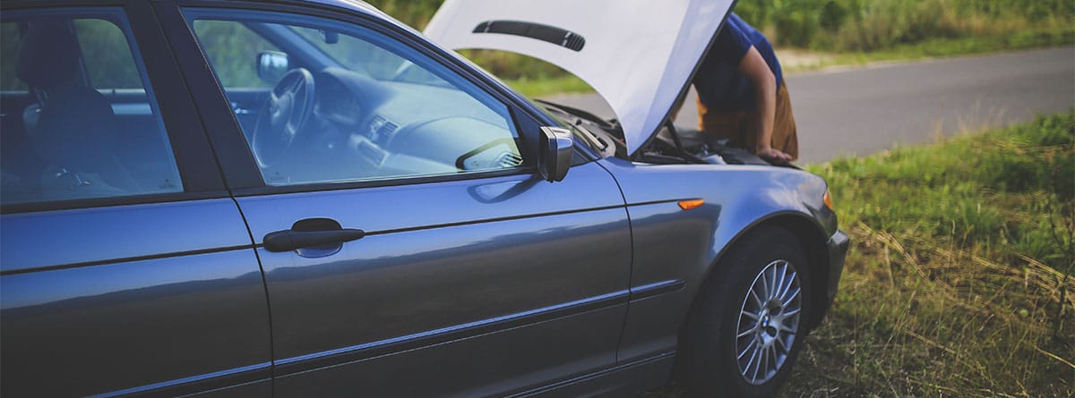 Man looking under the hood of a car