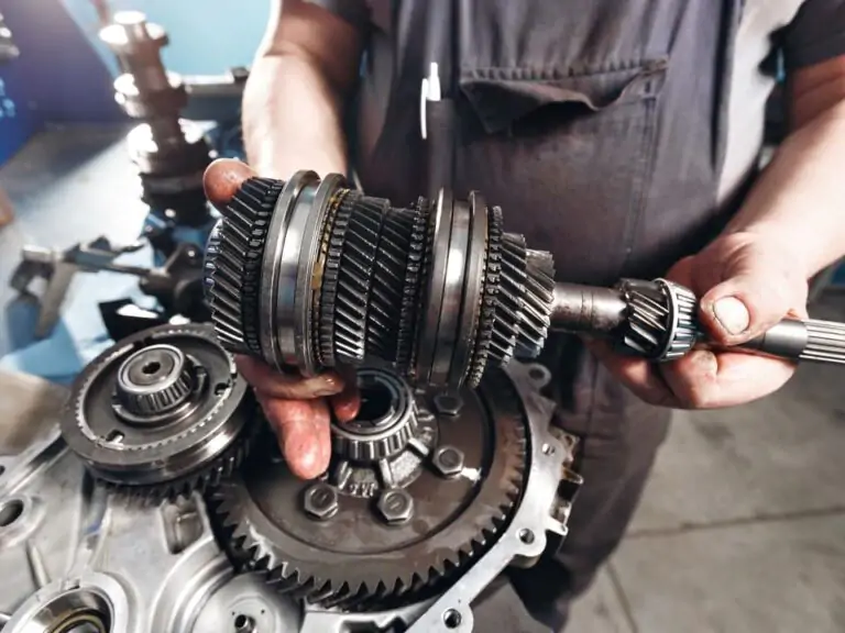 In a well-equipped garage, a skilled mechanic focuses on the intricate details of a car's transmission. With a wrench in hand, they meticulously tighten a bolt, ensuring optimal performance. Explore the precision and expertise required to maintain and repair crucial automotive components.