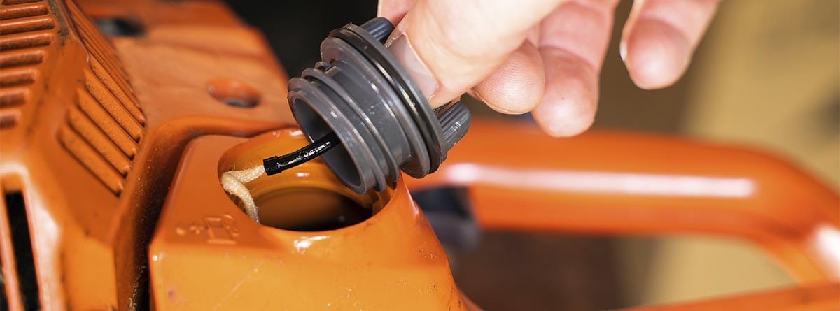 Hand unscrewing a motorcycle tank