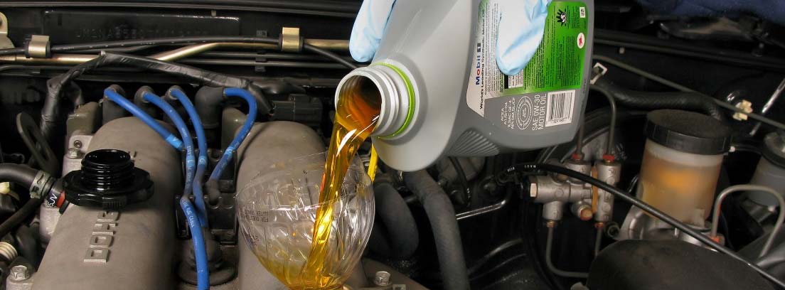 Hands pouring oil into a car tank